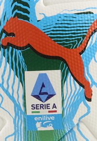 Piłka nożna Puma, biała powierzchnia o teksturze z zielonymi i niebieskimi akcentami. Zawiera czerwone logo skaczącego pumy oraz branding Serie A.