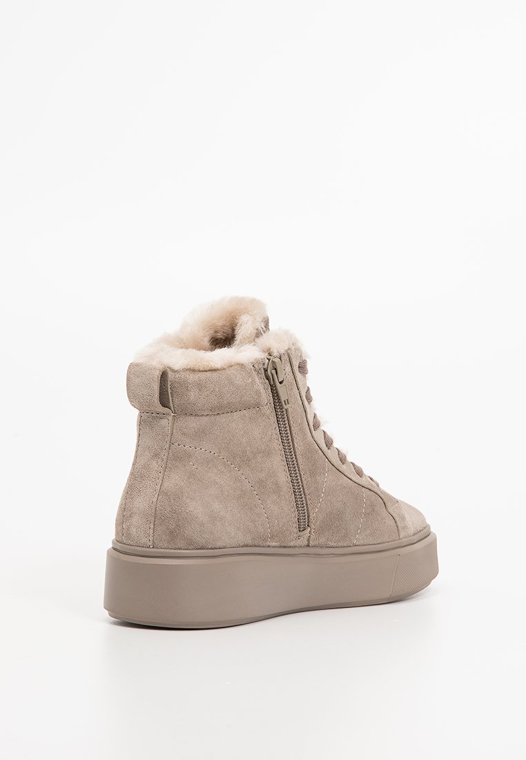 Beżowe zamszowe sneakersy typu high-top z puszystą futrzaną podszewką, zamkiem błyskawicznym z boku oraz grubą gumową podeszwą dla dodatkowego komfortu i przyczepności.