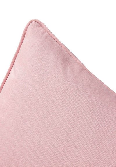 Γωνία απαλού ροζ υφασμάτινου μαξιλαριού με λεπτή υφή και ραμμένες άκρες σε λευκό φόντο.