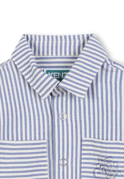 Chemise en coton rayée bleue et blanche avec un col classique, fermeture à boutons sur le devant et une poche poitrine gauche avec un détail brodé.