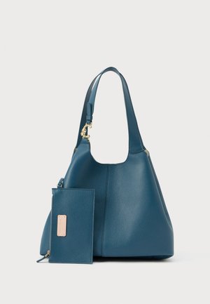 Mala de couro azul texturizado com alça larga e bolsa com fecho de correr combinando, com uma pequena etiqueta da marca bege.