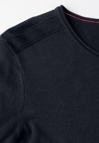 Mörkblå tröja med ribbat rundhals, som har ett slätt strukturerat tyg och en röd accent längs den inre kragen.