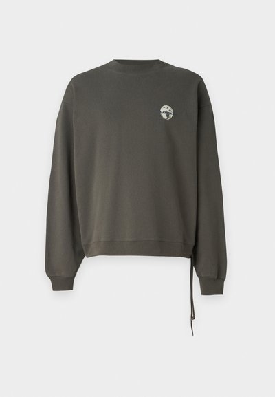 Tmavě olivově zelená mikina s dlouhými rukávy, kulatým výstřihem a nášivkou na hrudi. Obsahuje detaily s bočními šňůrkami.
