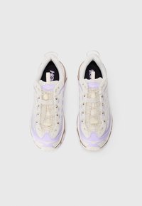 Baskets de sport avec un dessus en maille beige, des accents violets clairs, des lacets texturés et un col rembourré. Présente une semelle et un logo contrastants.