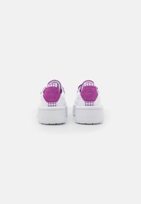 Weiße Plattform-Sneaker mit lila Wildlederakzenten, Gittermuster an den Fersenlaschen und gepolsterten Kragen. Glatte Textur mit einer massiven Sohle.