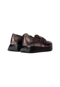 Zapatos de deslizamiento metálicos en bronce con un upper de cuero liso y un respaldo texturizado, que presentan una suela de goma negra con acentos decorativos.
