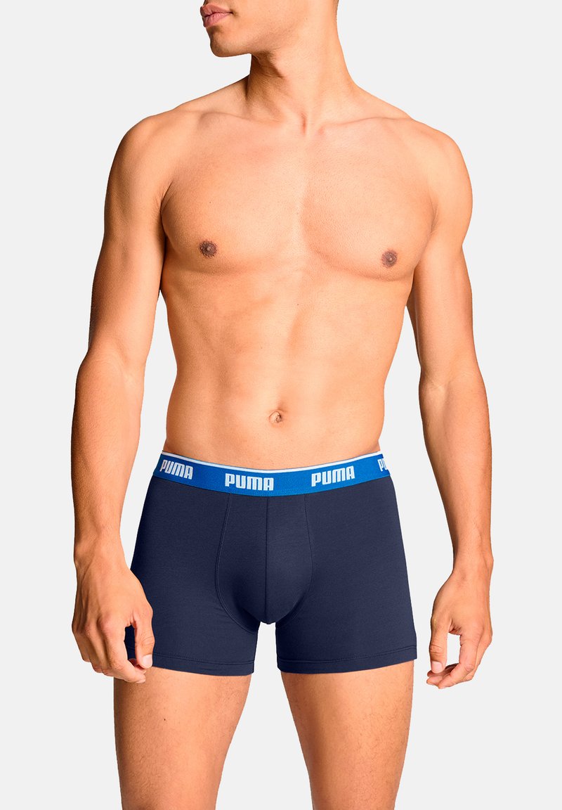 Marineblaue Herrenboxershorts aus dehnbarem Stoff mit einem kontrastierenden blauen Bund, auf dem das "PUMA"-Logo abgedruckt ist.