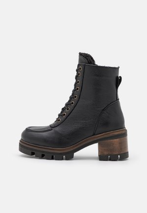 Czarny skórzany botek do kostki z sznurowanym przodem, wyściełanym wnętrzem, solidną podeszwą oraz masywnym, drewnianym obcasem na słupku.