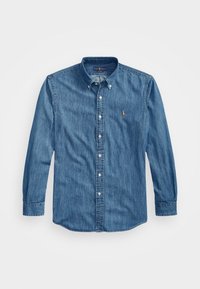 Camisa vaquera, de mangas largas, con cuello abotonado, color azul claro, con un pequeño logo bordado en el pecho, tela con textura.