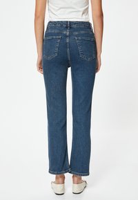 Högmidjade blå denimjeans med rak bendesign, tillverkade av strukturerat tyg, med två bakfickor och en vikta nederkant.