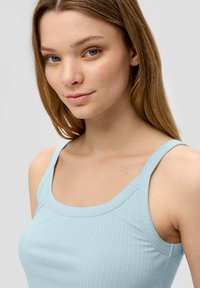 Hellblaues, geripptes Tanktop mit breiten Schulterträgern und rundem Ausschnitt. Glatte Textur und taillierte Passform. Keine sichtbaren Logos.