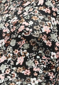 Μαύρο ύφασμα με λουλουδάτο σχέδιο από μικρά ροζ, λευκά και πράσινα λουλούδια. Το υλικό φαίνεται μαλακό με ελαφρύ γυάλισμα.