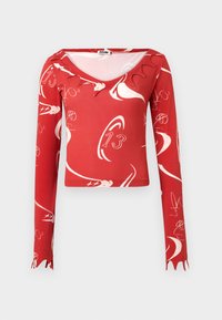 Rød langermet topp med rund hals, som har hvite abstrakte mønstre og bølget kant ved ermene. Laget av stretchmateriale.