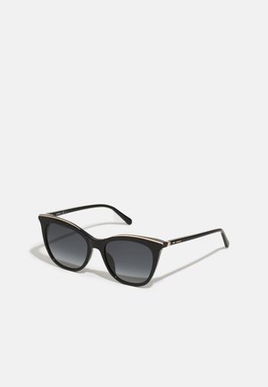 Schwarz gefärbte Cat-Eye-Sonnenbrille mit einem grauen Verlaufsglas und einem goldenen Metallakzent entlang des oberen Rahmens, ausgestattet mit schlanken schwarzen Fassungen und Bügeln.