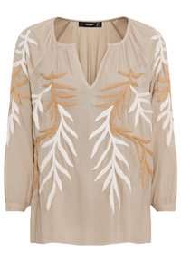 Blouse beige à manches longues avec col en V, tissu texturé et motifs de feuilles brodés blancs et marron clair sur le devant et les manches.