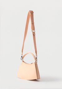 Μπεζ τσάντα χειρός με κοντή λαβή και ρυθμιζόμενο μακρύ λουρί ώμου, εμφανίζεται πάνω σε απλό ανοιχτόχρωμο φόντο.