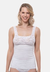 White tank top with lace trim, featuring a square neckline, slim straps, and a smooth texture. Layered design with a snug fit.