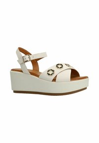 Witte wedge sandalen met een verstelbare enkelband, uitgerust met een gladde lederen bovenkant en drie kruislings banden voorzien van metalen accenten.