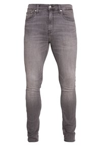 Pantalones vaqueros de mezclilla gris con corte ajustado. Cuenta con cinco bolsillos, pasadores para cinturón y una cremallera. Acabado deslavado con una textura suave.