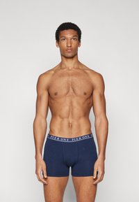 Boxer shorts en coton bleu marine avec une ceinture élastique contrastante arborant le texte "PIER ONE". Texture lisse et design ajusté.