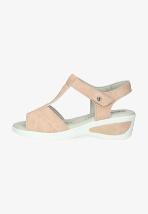 Sandalia de ante durazno con diseño de punta cerrada, correa ajustable y suela de cuña blanca con un acento texturizado en el lateral.