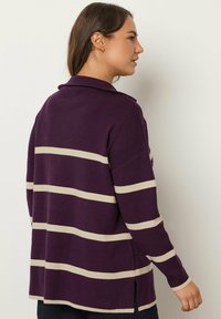 Lila gestreifter Pullover mit cremefarbenen horizontalen Streifen, mit Kragen, langen Ärmeln, seitlichen Schlitzen und einem lockeren Schnitt. Weiche Textur.