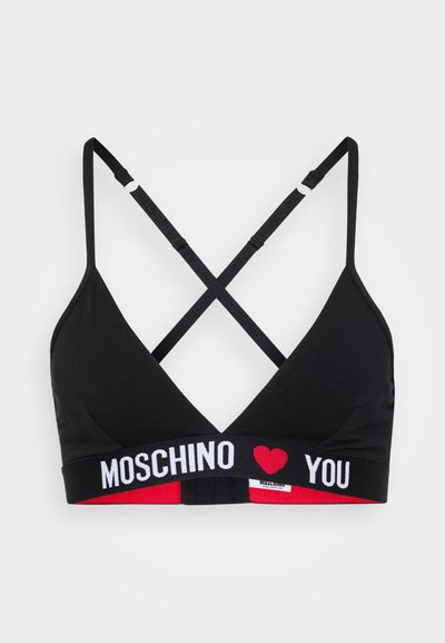 Melna bralette ar krustveida siksnām, kurai ir kontrastējoša elastīga lente ar uzrakstu "MOSCHINO ♥ YOU" baltā krāsā un sarkanu sirdi. 