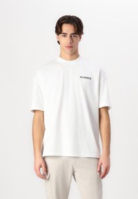White cotton t-shirt with short sleeves and a crew neck. Features black "ALLSAINTS" text logo on the left chest. Simple design and relaxed fit.