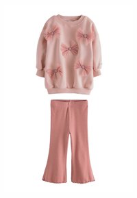 Tricou roz din material texturat, cu trei funde mari din tull, asociat cu pantaloni evazați roz, realizati tot din material moale.