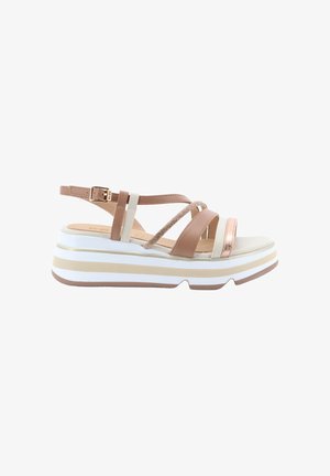 Sandalo con zeppa e cinturini beige, bianchi e oro rosa con chiusura a fibbia su una suola spessa a righe.