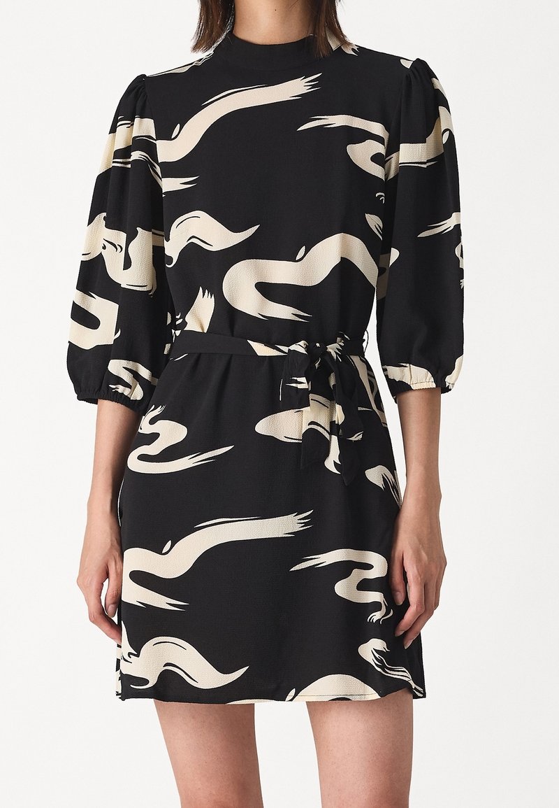 Robe noire avec motif abstrait tourbillonnant beige, manches trois-quarts bouffantes, col montant et ceinture assortie en tissu, nouée à la taille.