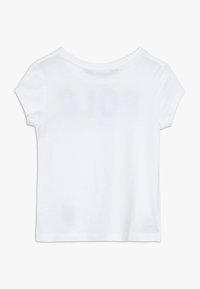 Camiseta de cuello redondo de manga corta, blanca y lisa, mostrada en plano, exhibiendo el lado posterior sobre un fondo blanco.