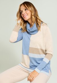 Lightweight, cowl-neck sweater with a color block design in light blue, beige, and soft brown. Features long sleeves and side slits.