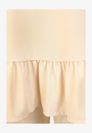 Tejido de color beige claro con un dobladillo con volantes y una textura suave. El diseño es simple y sin adornos, sin patrones ni acentos visibles.