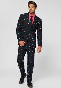 Black suit with a Pac-Man design featuring colorful patterns and characters. Pink shirt and tie, glossy black shoes. Tailored fit.