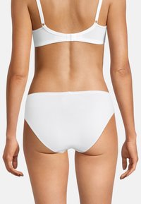 Weißer Baumwoll-Bralette und passende Slips präsentieren ein glattes Finish, nahtloses Design und einen zurückhaltenden Stil mit verstellbaren Trägern.