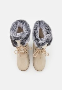 Botas impermeables beige con un cuello de piel sintética gris acolchado, diseño de cordones y suela de goma texturizada. Adecuadas para condiciones de clima frío.