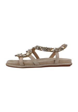 Sandali piatti beige con tre cinturini e una tomaia decorata con accenti metallici e strass. Soletta testurizzata e suola glitterata.