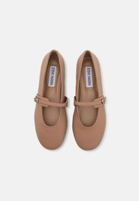 Bailarinas en tono beige, hechas de suave cuero sintético. Presentan una punta redonda, una correa estilo Mary Jane con un cierre de metal y una plantilla acolchada.