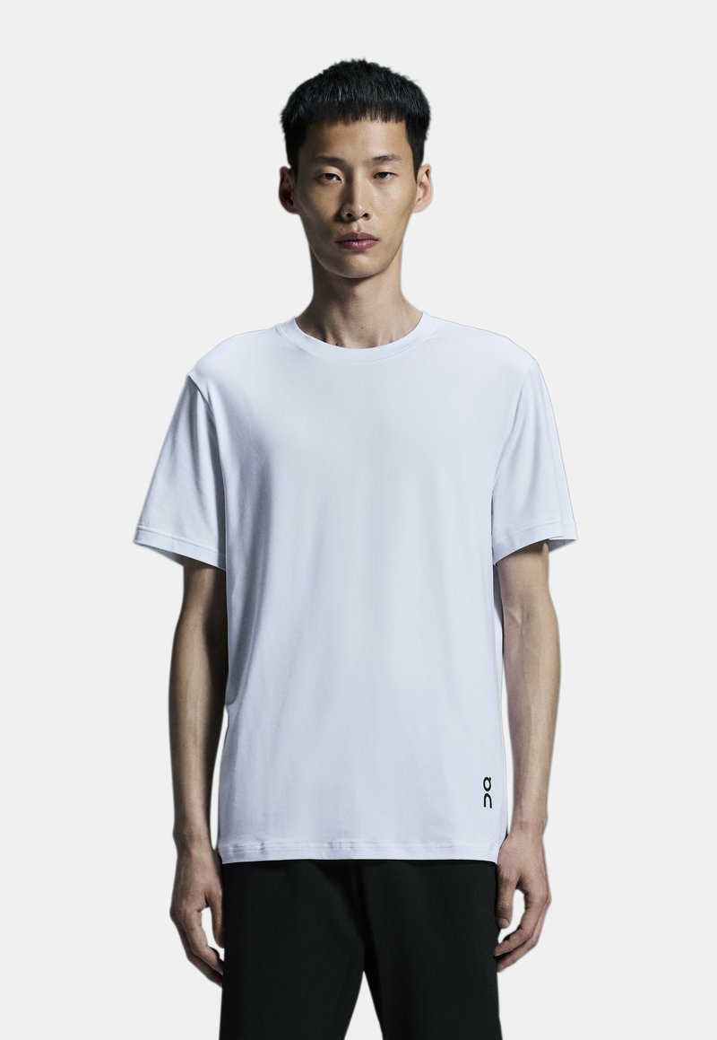 White short-sleeve t-shirt made from soft fabric, featuring a round neckline and a small black logo on the lower side.