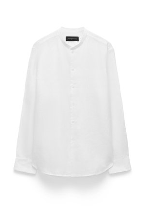 Camicia bianca a maniche lunghe con bottoni e colletto alla coreana, dotata di una tasca sul petto, esposta su sfondo bianco.