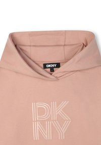 Hoodie rose clair avec une poche kangourou, présentant un logo DKNY texturé en police bloc. Matière en coton doux et capuche ajustable.
