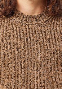 Maglione marrone lavorato a maglia con un motivo testurizzato, dotato di un collo a costine e una vestibilità ampia, realizzato in un morbido filato spesso.