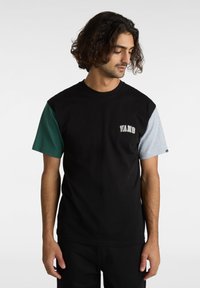 Svart bomull t-shirt med gröna och grå korta ärmar, med "VANS" logotypen på bröstet. Avslappnad passform med rund hals.