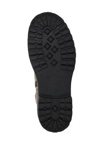 Zwarte rubberen schoenzool met diepe profielen en een gestructureerd patroon. Bruine stoffen bovenkant gedeeltelijk zichtbaar langs de randen. Maat 31 gemarkeerd.