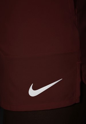 Bordeaux atletikshorts med en glat overflade, med et hvidt Nike swoosh-logo på nederste venstre side. Simpelt, funktionelt design.