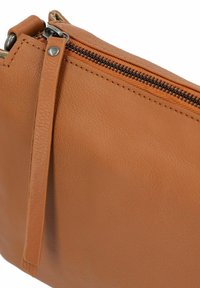 Borsetta in pelle marrone con superficie testurizzata, dotata di una cerniera nera e di un tirante in pelle coordinato. Design compatto e versatile.