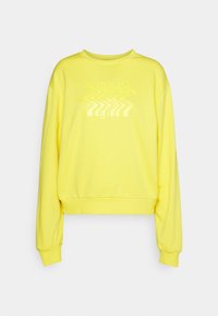 Sudadera amarilla con cuello redondo, mangas largas y un dobladillo corto. Presenta un gráfico de texto ondulado en un tono amarillo a juego.