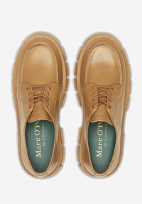 Chaussures en cuir tan avec une finition lisse, bout rond et semelle en caoutchouc épaisse. Comprend des lacets et une semelle intérieure verte avec une marque dorée.