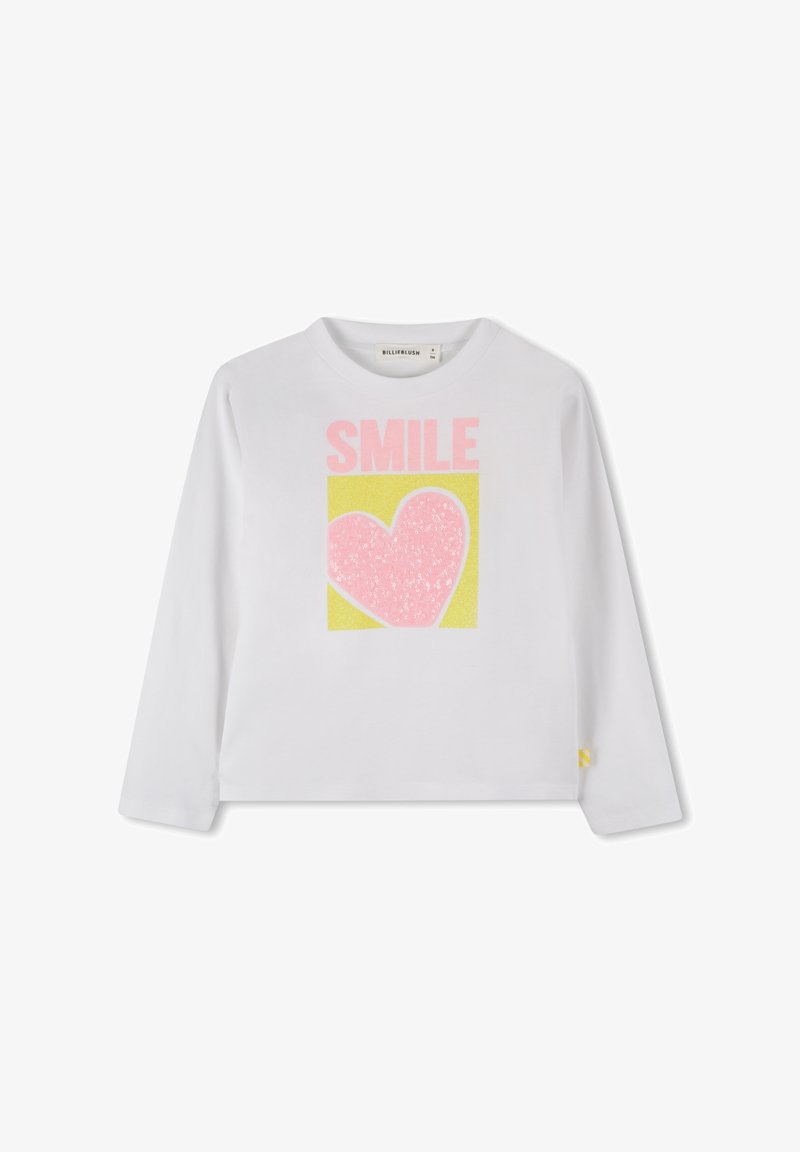 Hvit langermet skjorte med et fargerikt "SMILE"-grafikk og et rosa hjerte på en gul bakgrunn. Laget av mykt bomullsmateriale.